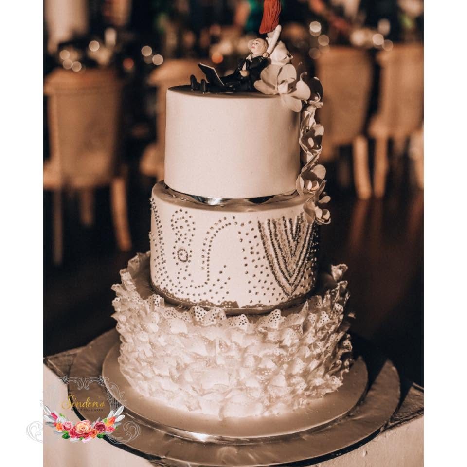 Four-tier textured wedding cake with florals in a romantic venue