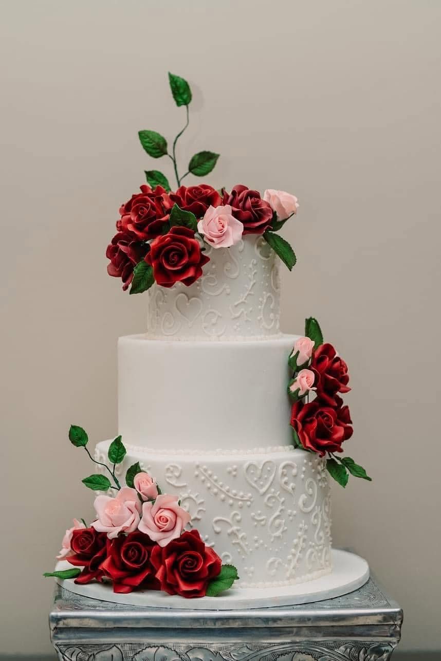 White cake with burgundy roses and greenery